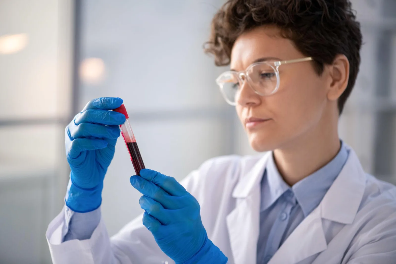 Laboratory technician analyzing a blood sample under precise clinical conditions